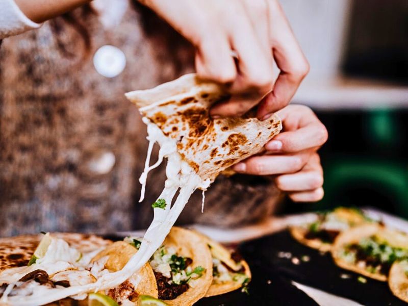 Cliente probando quesabirria en la terraza del local