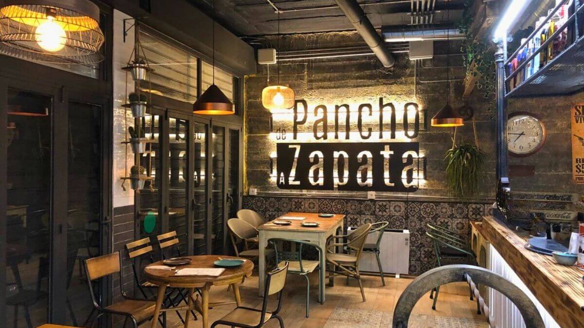 Interior del restaurante mexicano De Pancho a Zapata en Torrelodones con logo iluminado en pared