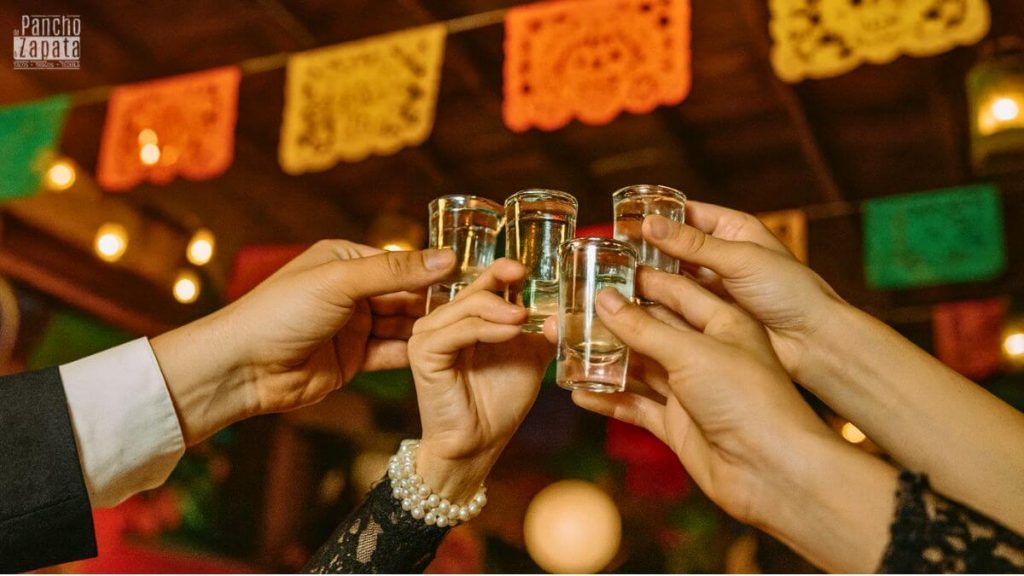 Brindis con shots de mezcal en ambiente mexicano festivo