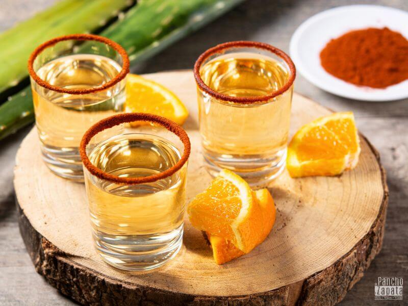mezcal servido con sal de gusano y rodaja de naranja