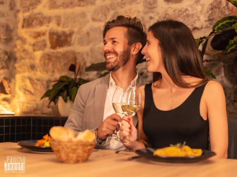 Pareja disfrutando cena romántica en terraza mexicana