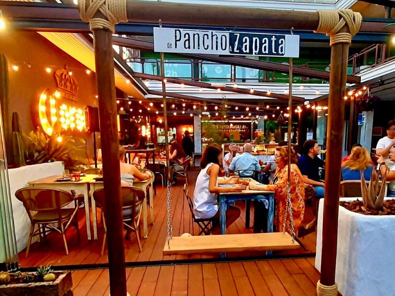 Clientes disfrutando de comida mexicana en grupo, brindando en el restaurante De Pancho a Zapata.