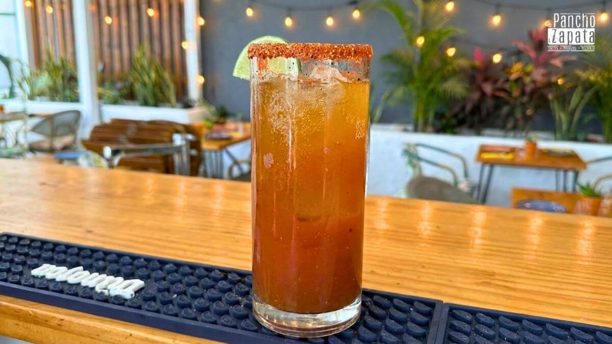 Primer plano de michelada mexicana helada con borde de sal y tajín en restaurante De Pancho a Zapata, ideal para curar la resaca.