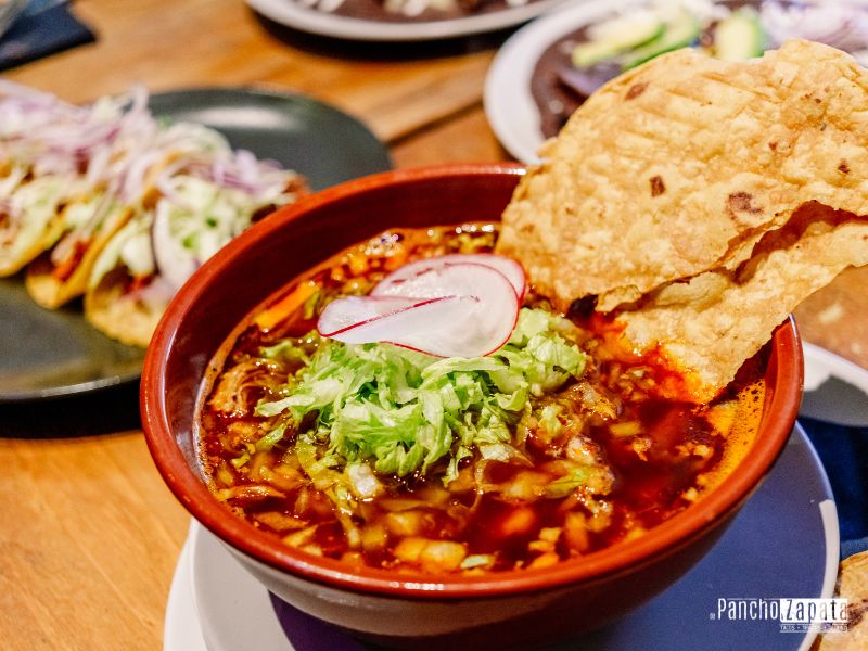 Plato hondo de Pozole Rojo estilo Michoacán con granos de maíz y carne, ideal para el frío en la Sierra de Madrid.