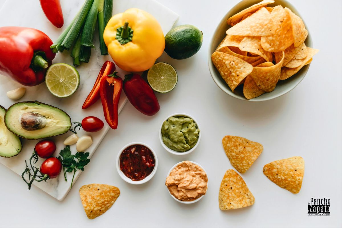 Ingredientes verdes frescos como cilantro y salsas que representan la esperanza en la bandera mexicana.