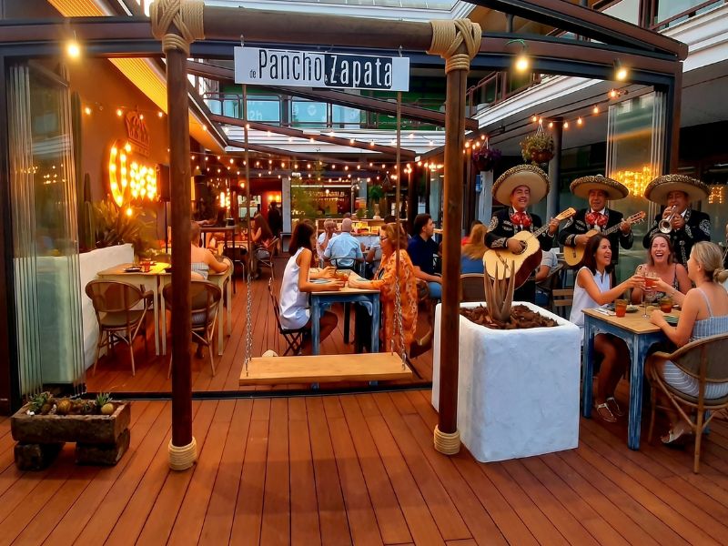 Clientes cenando tacos en la terraza de De Pancho a Zapata mientras disfrutan del show de mariachis en vivo en Torrelodones.