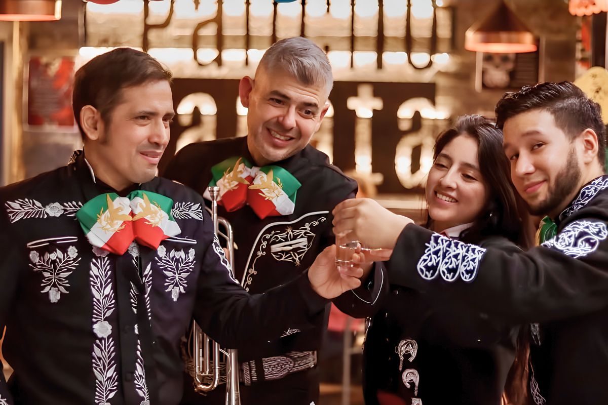 Músicos mariachis tocando la guitarra y la trompeta en directo en el restaurante De Pancho a Zapata