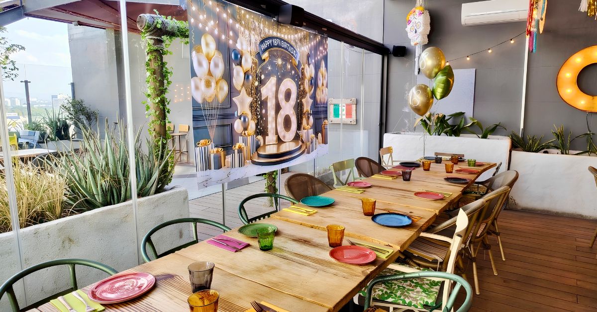 Terraza de De Pancho a Zapata preparada para una celebración de cumpleaños en grupo, con mesa larga y vajilla de colores